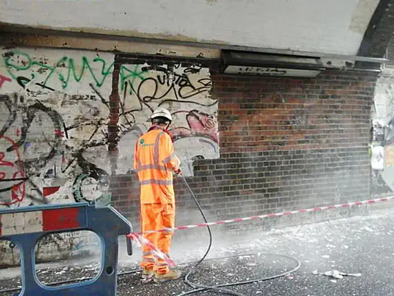 One of our graffiti removalists cleaning the graffiti off a wall in Geelong