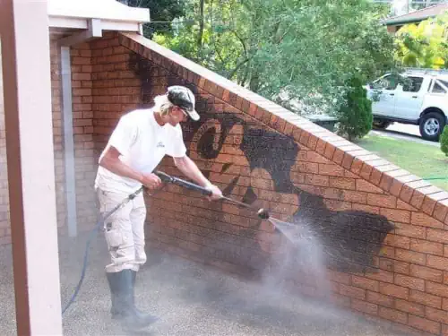 Graffiti being removed from bricks on a residential property in Geelong.